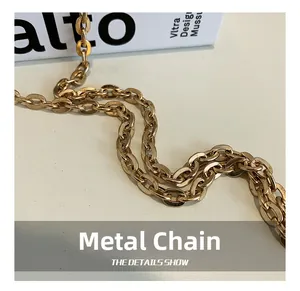 Detail showing the glossy golden metal chain strap of the stylish box handbag