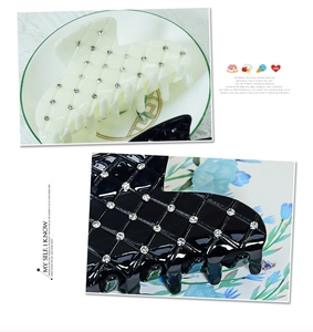 Detail of elegant black and white quilted claw clips with rhinestones on a ceramic dish