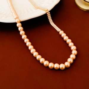 Detail of elegant champagne pearl necklace with rectangular zircon crystals on a dark base