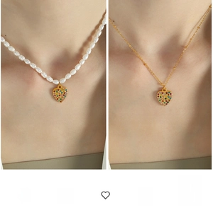 Macro shot of colorful zircon heart pendant on baroque pearl necklace and gold chain