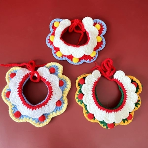 Détail de trois écharpes pour animaux au crochet avec pompons colorés et texture de laine douce