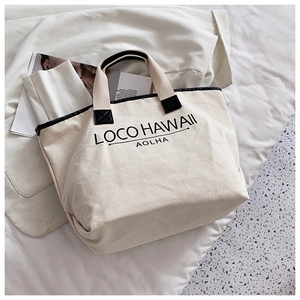 Detailansicht der cremefarbenen Canvas-Tasche mit schwarzen Henkeln und LOCO HAWAII-Print