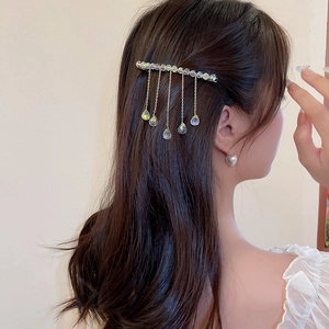 Detail of crystal fringe hair clip with gold alloy body and sparkling tassel pendants