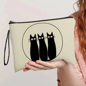 Portable beige canvas makeup bag featuring three black cat prints and wrist strap
