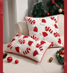 Detailansicht der getufteten Weihnachts-Kissenhülle mit roter Paspel auf dem Sofa