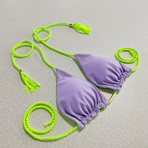 Detail of lavender bikini top with lime green braided straps and golden metal accents