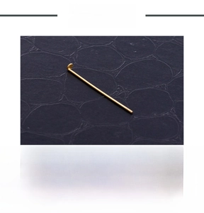 Macro detail of a 0.5g gold-plated stainless steel flat head pin for DIY jewelry making