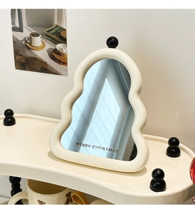 Close-up of white wavy Christmas tree tabletop mirror with black Merry Christmas text