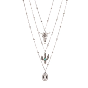 Detail of retro silver layered necklaces with bull skull, cactus and turquoise pendants