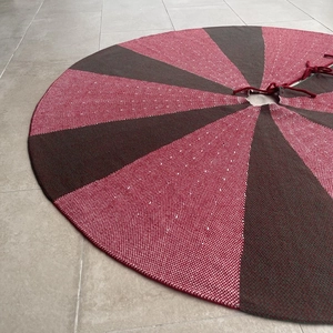Close-up of a 48-inch red and black knitted Christmas tree skirt with thick yarn texture