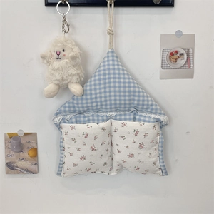 Détail d'un sac de rangement mural en forme de maison avec tissu à carreaux et dentelle