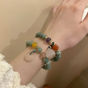 Close-up of beaded chalcedony bracelet featuring a lotus pod charm on a model's wrist