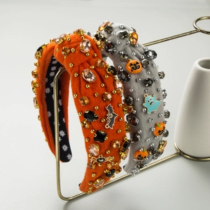 Macro detail of Halloween headband with rhinestones, pumpkin charms and spider motifs