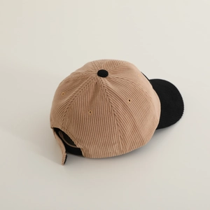 Top view of color-block corduroy baseball cap with beige crown and black brim detail