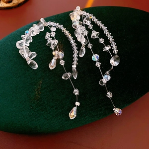 Detailed macro shot of irregular crystal tassel earrings on green velvet cushion