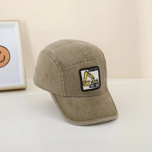 Close-up of khaki washed cotton camper hat featuring a yellow excavator patch detail