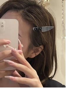 Detailed view of a creative mini cleaver hair clip in black and silver on hair