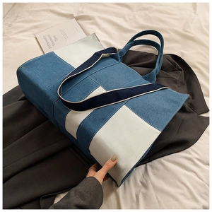 Detail of a denim patchwork tote bag with H-shaped design and fabric shoulder strap
