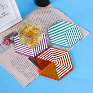 Close-up of hexagonal resin coasters with geometric stripes and glitter accents