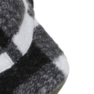 Close-up of thick plush checkerboard fabric with high-quality stitching on a warm winter cap