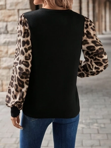Detail of leopard print patchwork sleeves on black crew neck long sleeve top for women