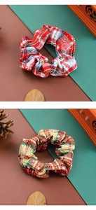 Detail of red and beige plaid hair scrunchies with festive pine cones background