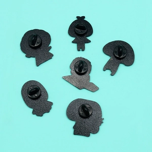 Detailed back view of enamel pins featuring secure black rubber clutches on blue background