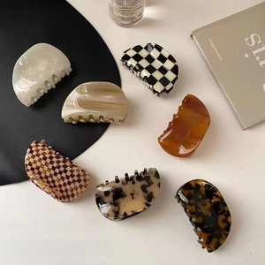 Flat lay of large acetate hair claws in tortoise shell, marble, and checkerboard patterns