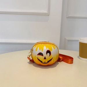 Detail of pumpkin-shaped crossbody bag with smiley face and striped wide strap