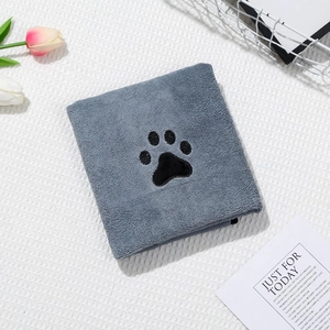 Close-up of thick grey coral fleece towel with a black paw print embroidery for pets
