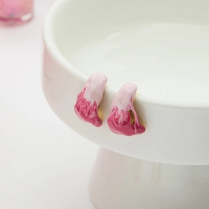 Close-up of pink and white gradient drop glaze earrings on a white ceramic display stand