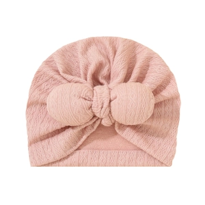 Detailed close-up of pink baby turban hat featuring jacquard texture and knit bow tie