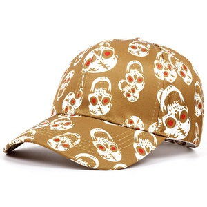 Close-up of mustard yellow baseball cap featuring all-over skull print with red eye details