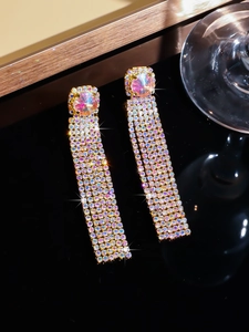 Macro shot of sparkling rainbow rhinestone tassel earrings with a polished gold finish