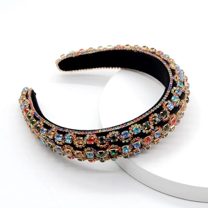 Detailed close-up of wide velvet headband with colorful rhinestones and gold metal studs