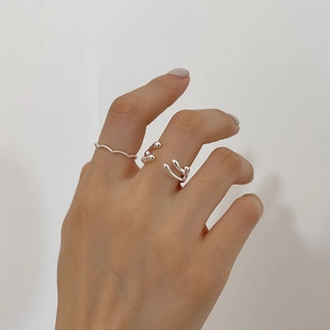 Detail of 925 sterling silver wavy rings and liquid metal style open bands on hand