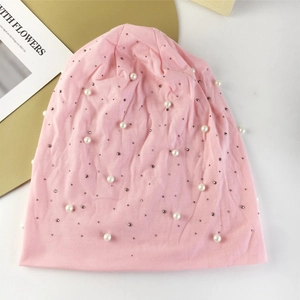 Bonnet en tricot rose orné de perles blanches et de petits rivets argentés