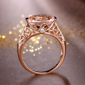 Detailed macro view of an oval pink morganite ring with rose gold filigree and diamonds