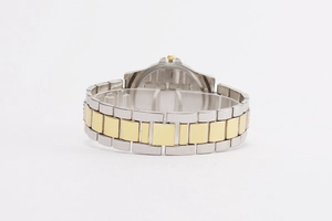 Detail view of the silver and gold two-tone metal link watch strap with polished case back