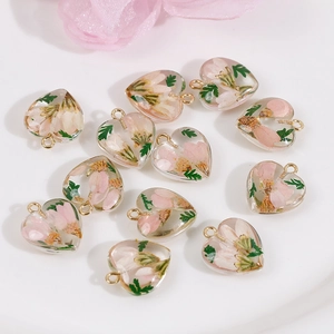 Handmade heart resin pendants with pink dried flowers and green leaves for DIY jewelry