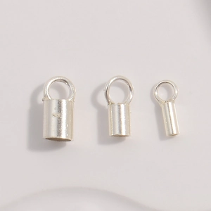 Detailed view of three polished S925 sterling silver cord end caps in various sizes