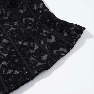 Vue macro de la dentelle florale et de la structure de soutien en satin sur corset noir