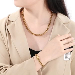 Detailed view of chunky gold chain necklace and bracelet set with OT toggle clasp