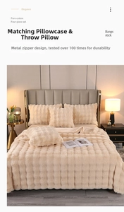 Close-up of beige faux fur blanket featuring square quilted texture and premium stitching