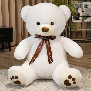 Detail of white plush teddy bear with Just for you ribbon and heart paw prints
