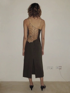 Detail of backless maxi dress with intricate spider web mesh cutout and slit design
