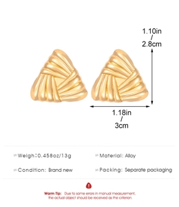 Macro detail of golden alloy earrings with radial texture and 2.8cm x 3cm size specs