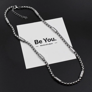 Detail of square pearl box chain necklace with textured metal cylinders and lobster clasp