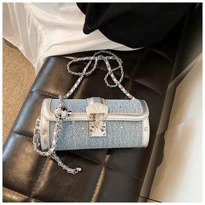 Detail of blue denim crossbody bag with rhinestones, silver trim, and chain strap
