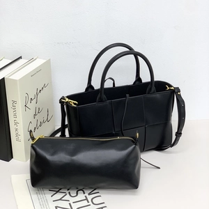 Detail of black woven leather tote bag including matching internal cylinder pouch